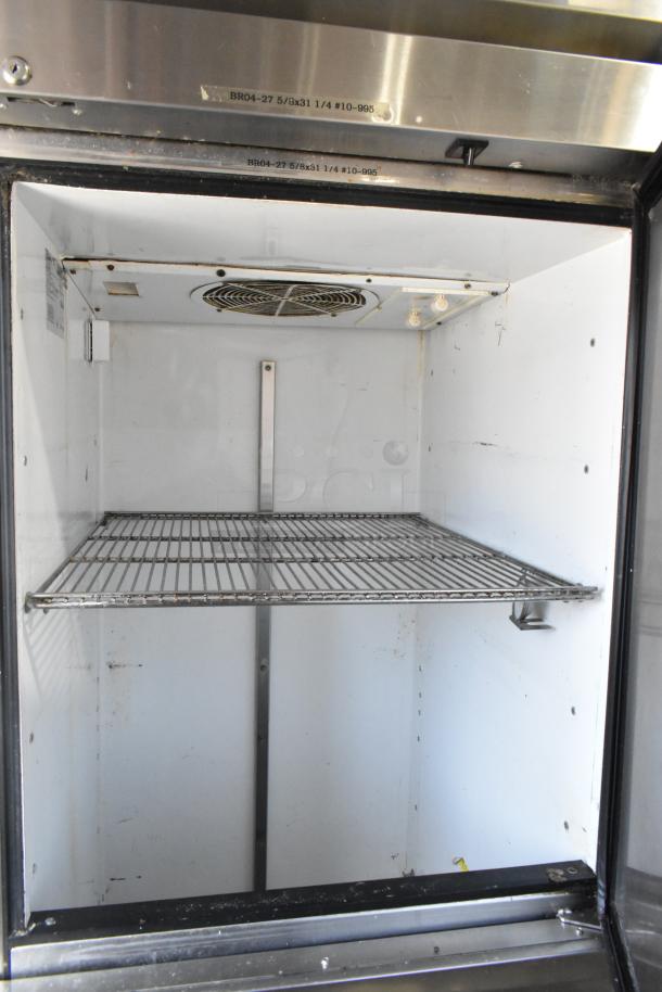True TA1R-2HS commercial reach-in cooler, 2 half-size doors, on commercial casters, 115 volts, shows interior and shelving.