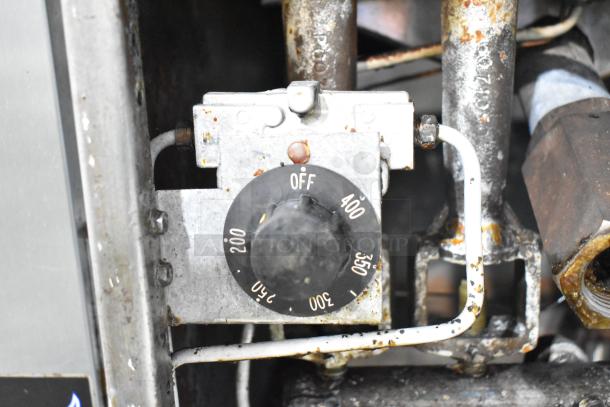 Pitco Frialator commercial gas fryer control knob and piping, showing temperature settings from 200 to 400 degrees. Visible wear.