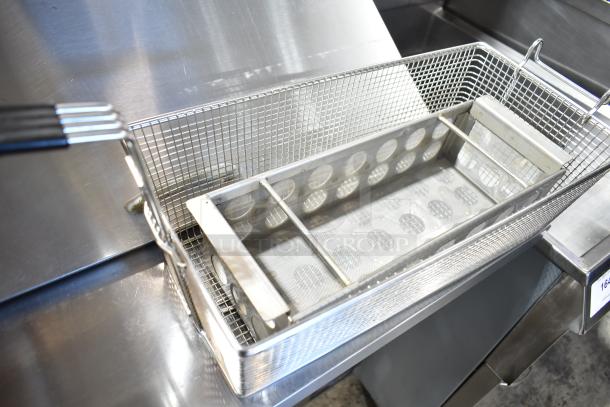 Brand new metal fry basket with a sturdy wire design and mesh base. Includes a black handled, ergonomic grip.