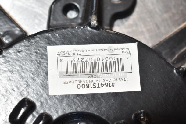 Metal table piece with label showing “#164TS1800,” “LBS 18” cast iron table base.” Made in China, new with minor dents.