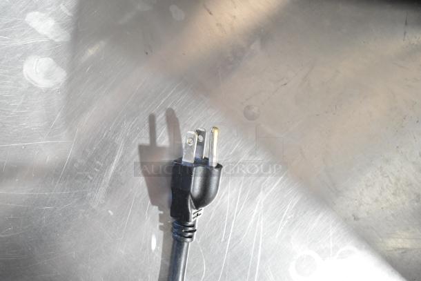 Power cord plug for Robot Coupe CL50 Ultra Food Processor, 120 Volts, 1 Phase, visible against a metallic surface.
