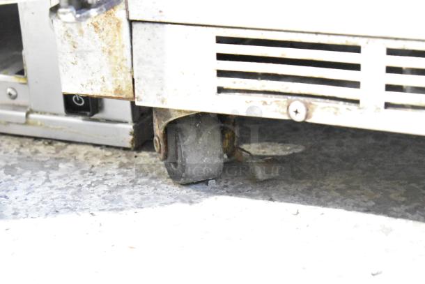 Beverage Air UCR34 undercounter cooler with commercial casters, visible wear. Power switch and vent shown. 115 volts, 1 phase.