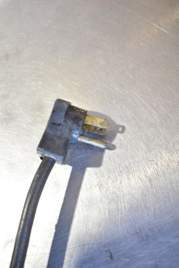 Close-up of a power plug of a Beverage Air UCR34 cooler, showing 115V connection. Plug appears in good condition.