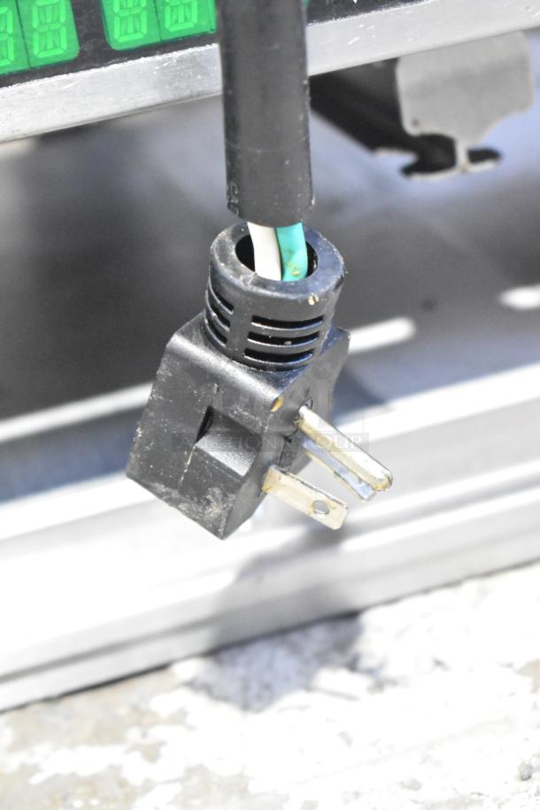 Commercial countertop dedicated holding bin power plug, black with exposed prongs, attached to green and white wiring.