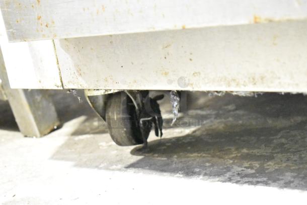 2022 Traulsen G12010 commercial freezer base with visible caster. Stainless steel, some surface wear, on industrial flooring.