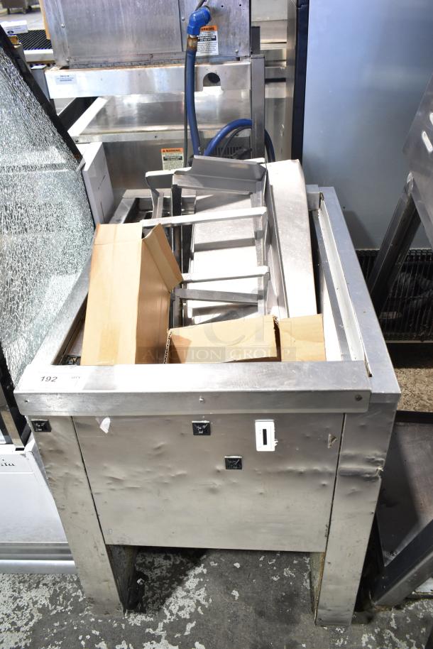 Single well prep station on commercial casters, stainless steel, with visible wear and dents. Includes storage area and rollers.