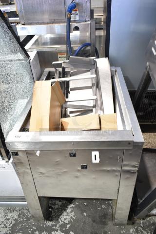 Single well prep station on commercial casters, stainless steel, with visible wear and dents. Includes storage area and rollers.