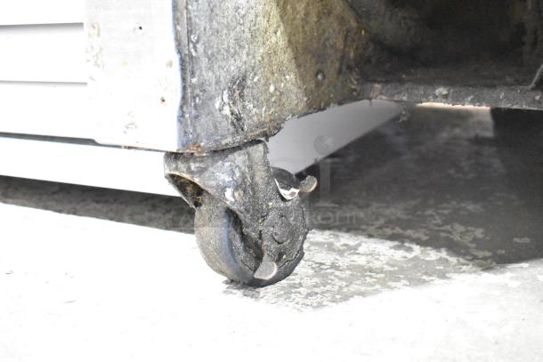 Single Well Prep Station on commercial caster, showing wear and rust. Suitable for kitchen or restaurant use.