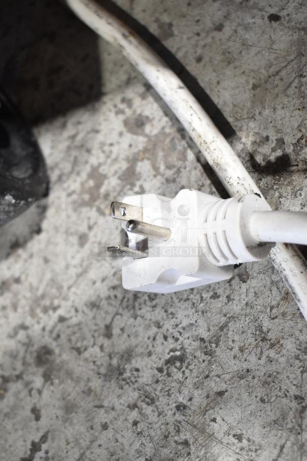 White power plug for Turbo Air TOM-50B-N Open Air Merchandiser, 115V, shown on a concrete surface.