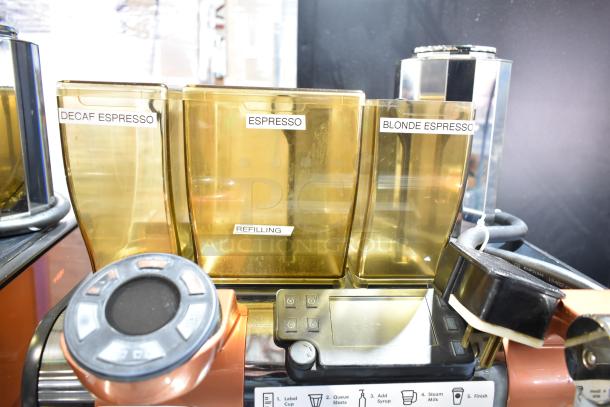 Thermoplan Mastrena II CS stainless steel espresso machine with steam wand, labeled coffee bean hoppers, and control panel.