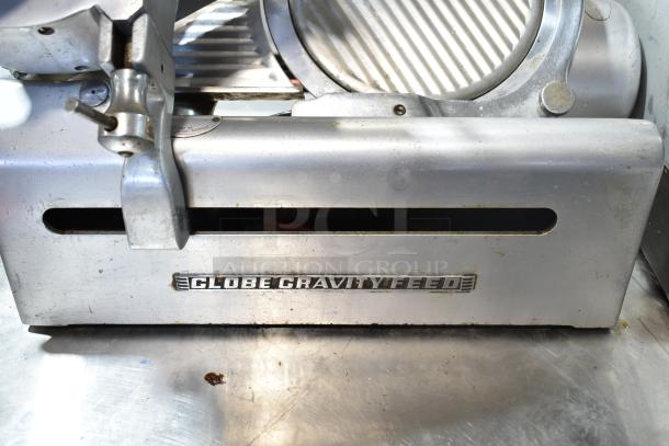 Globe commercial countertop automatic meat slicer with blade sharpener, silver, 115 volts, 1 phase, "Globe Gravity Feed" label.