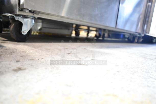 Avantco 178AU60R commercial 2-door undercounter cooler on casters, stainless steel, 115 volts, shown on warehouse floor.