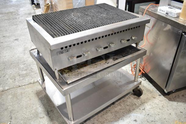 Vulcan commercial countertop gas-powered charbroiler grill on equipment stand with casters, visible wear, stainless steel build.