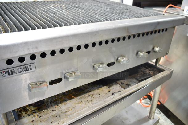 Vulcan commercial countertop gas charbroiler grill on equipment stand with casters, featuring visible control knobs.