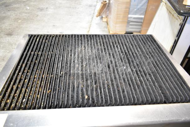 Vulcan commercial countertop gas charbroiler grill, used, on equipment stand with casters, steel grates, visible grease residue.
