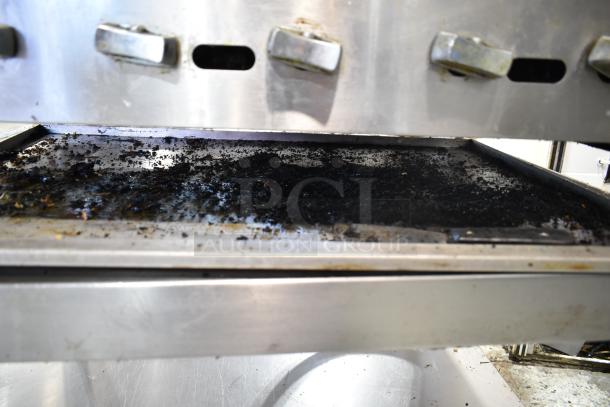 Vulcan commercial countertop gas charbroiler grill, well-used, on stand with commercial casters, showing grease buildup.