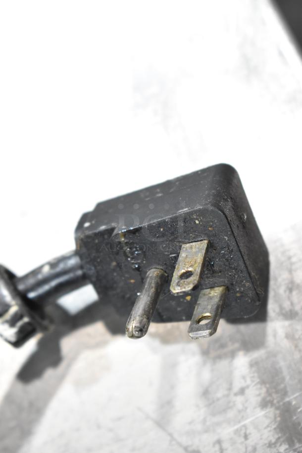 Close-up of a worn electrical plug for the Everest EPBR2 prep table, showing metal prongs with visible wear and dirt.
