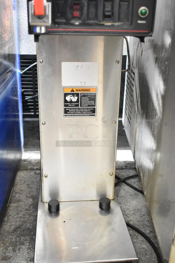 Bunn commercial countertop coffee machine with hot water dispenser, stainless steel, visible safety warning label, used condition.