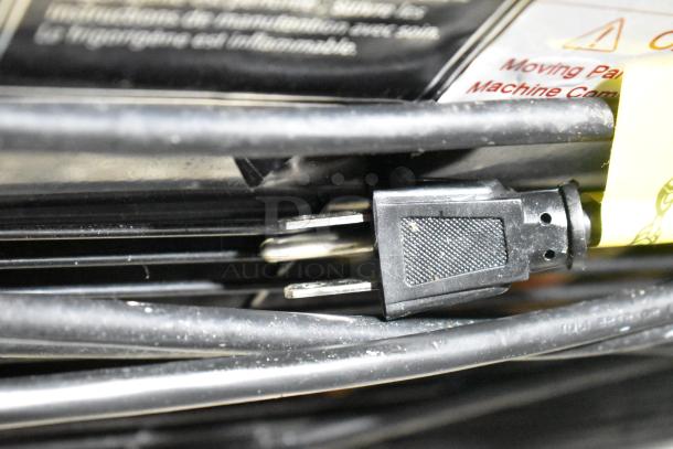 Close-up of the power cord and plug for the IDW Commercial Single Door Reach-In Cooler Merchandiser, 115 Volts, 1 Phase.