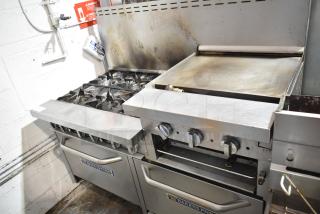 Bakers Pride commercial gas range with 6 burners, flat top griddle, cheese melter, 2 ovens, and backsplash. Good condition.