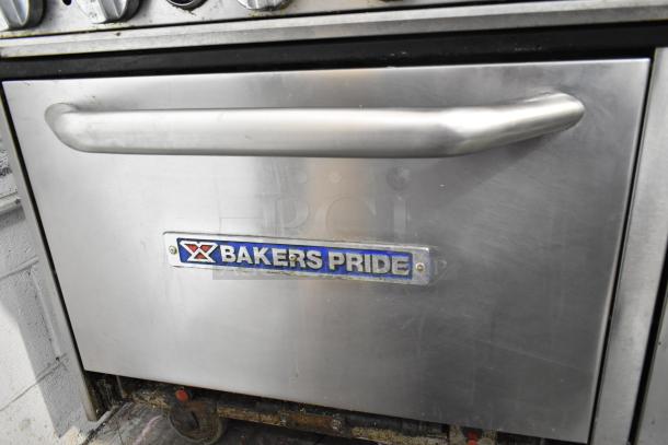 Bakers Pride commercial gas range with 6 burners, flat top griddle, cheese melter, 2 ovens, and backsplash. Visible branding.
