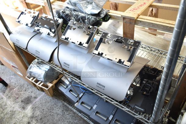 5 Micros Oracle POS docking stations on a metal shelf, used condition, includes mounting brackets, visible Micros Oracle branding.