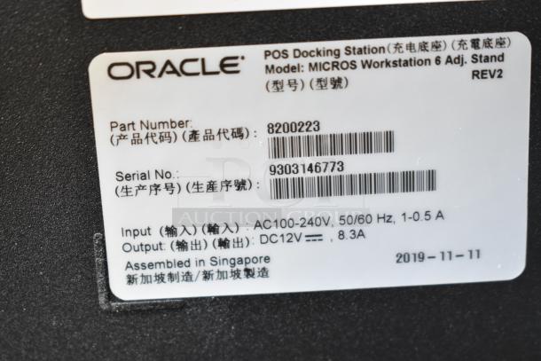 Oracle POS Docking Station tag showing model: MICROS Workstation 6, part number: 8200223, serial: 9303146773, assembled in Singapore.