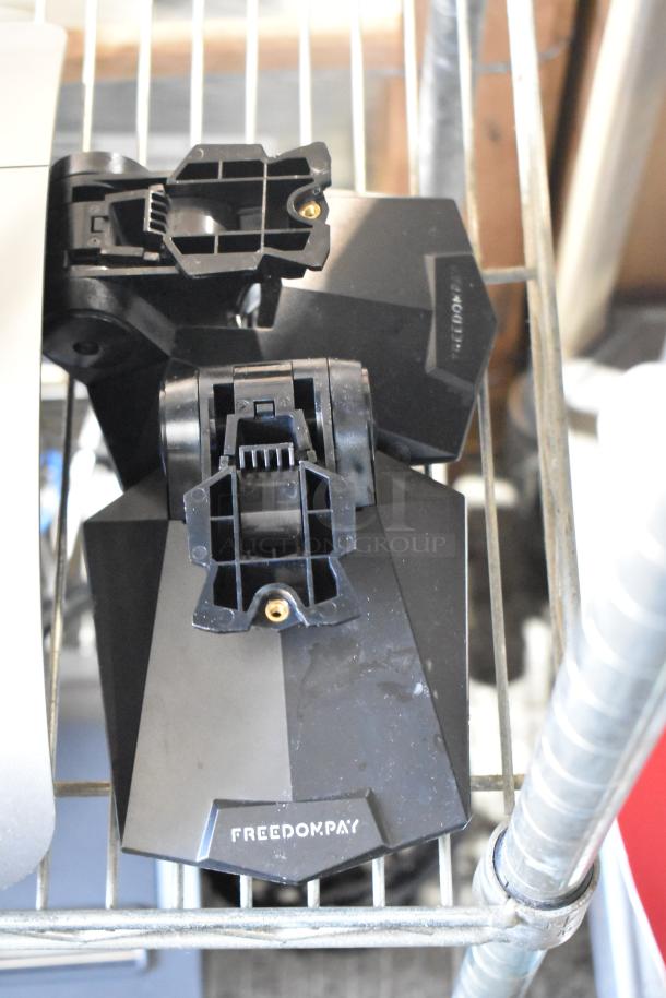 5 Micros Oracle POS docking stations, black, used, with FreedomPay branding. Includes adjustable brackets.