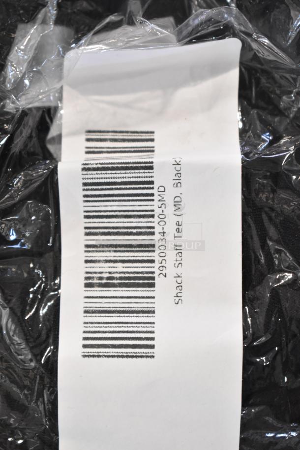 Plastic-wrapped package with barcode and "Shack Staff Tee (MD, Black)" label, indicating new unisex tees.
