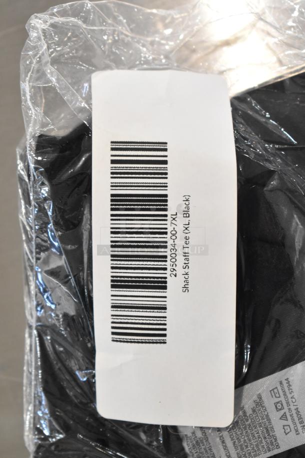 9 brand new scratch and dent items, including unisex Steff tees. Sizes include 2X. Barcode label reads "Shack Staff Tee (XL, Black)."