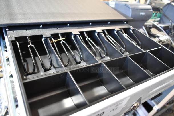 Open Oracle cash drawer with various compartments, alongside Epson M244A receipt printers and Lenovo 11UG keyboard.