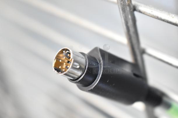 Close-up of a black connector cable with a metal multi-pin plug, likely part of the 9-item tech bundle auction.