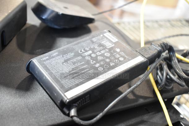 9 electronic components including a Lenovo charger with visible specifications, cables, and a black casing.