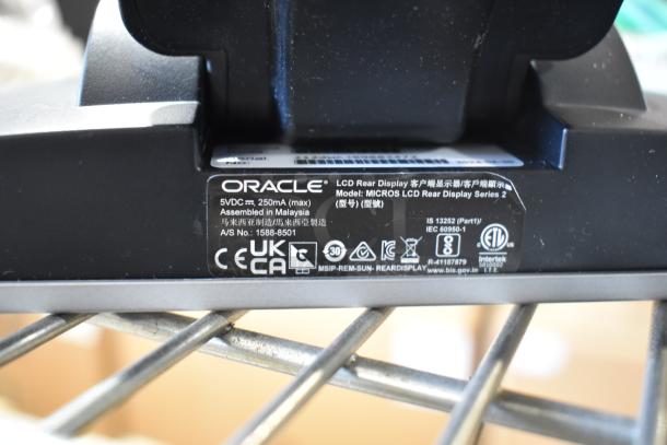 Oracle MICROS LCD rear display, 5VDC 250mA, assembled in Malaysia, A/S No. 1588-8501, certification labels visible.