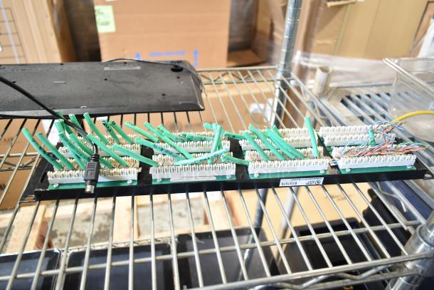 Nine assorted electronic items on metal rack, including Oracle cash drawer, Epson M244A receipt printers, Lenovo 11UG, and keyboard.