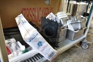 Lot of stainless steel drop-in bins, black matting, utensils, and Empress box on metal cart, good condition.