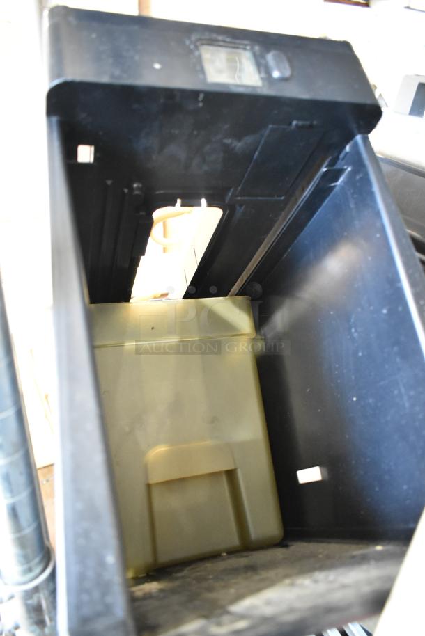 Large black plastic bin with compartment, includes digital display on top. Shows moderate wear, ideal for storage.