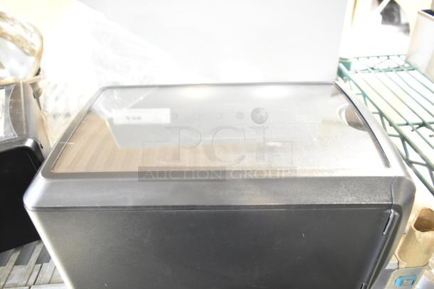 Two countertop napkin dispensers, black finish, clear top, in excellent condition. Visible label on top indicates model.