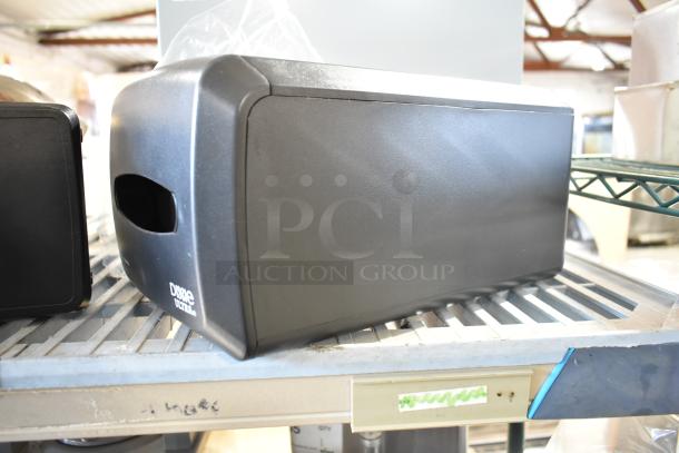 Two black Dixie Ultra countertop napkin dispensers, gently used, with side opening for easy access, shown on a metal shelf.