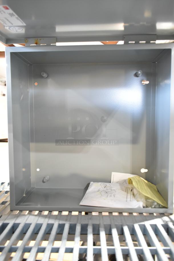 Dayton A16N16ALP gray enclosure, new condition, open showing interior space, inspection documents inside.