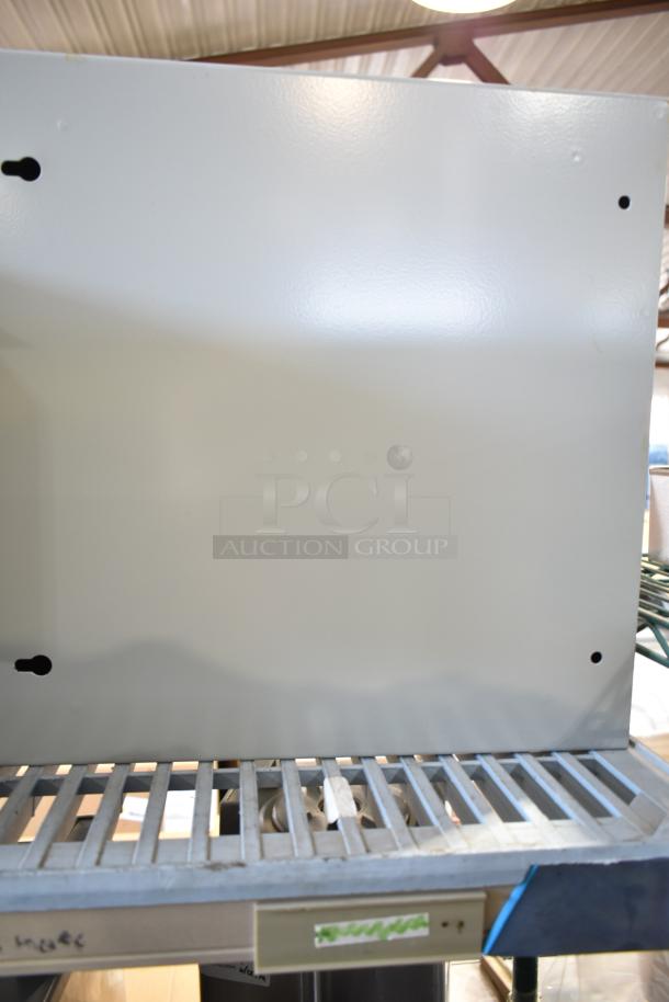 Dayton A16N16ALP gray enclosure on shelf, in excellent condition, solid construction, no visible markings.