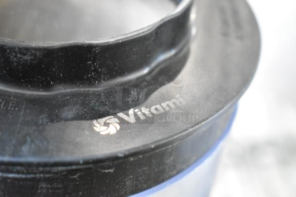 Vitamix blender pitcher lid showing brand logo, part of a mixed lot including metal cup and bowls, used condition.