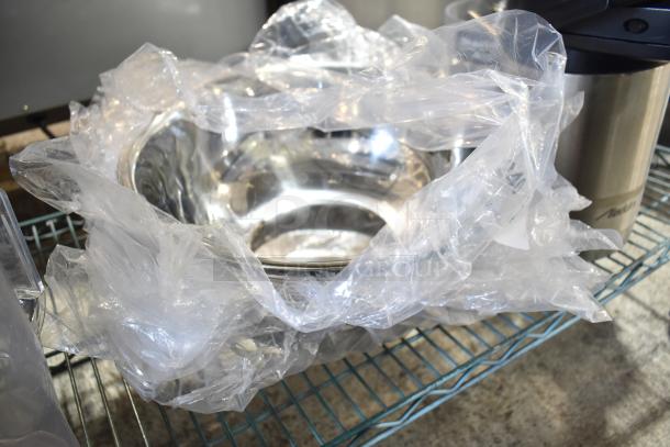 Tier lot with blender pitcher, metal cup, and bowls. Items wrapped in plastic, stored on a metal rack. Mixed conditions.