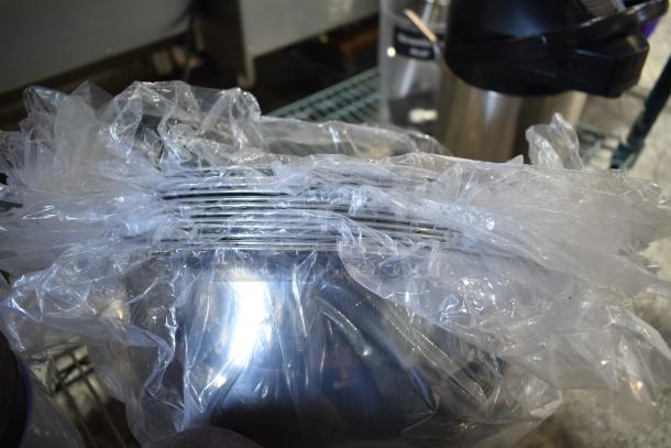 Bundle of kitchen items including a blender pitcher, metal cup, and metal bowls, wrapped in clear plastic, new condition.