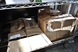 Boxes of new Acopa and Libbey glassware, including Memphis, Collins, and Irish Coffee Glasses on metal shelving.