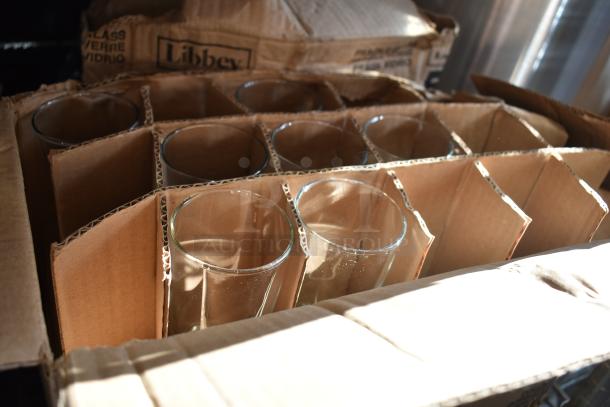 Box of brand new glassware including Acopa Memphis rocks glass, Libbey Collins glass, and Libbey Irish coffee mug.