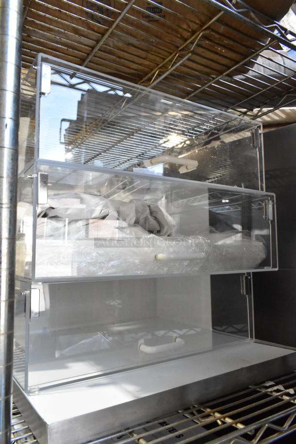 Brand new countertop dry display case merchandiser, clear acrylic with metal hinges, showing minor scratches and dents.