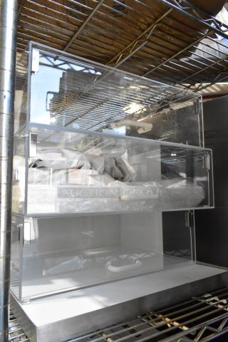 Brand new countertop dry display case merchandiser, clear acrylic with metal hinges, showing minor scratches and dents.