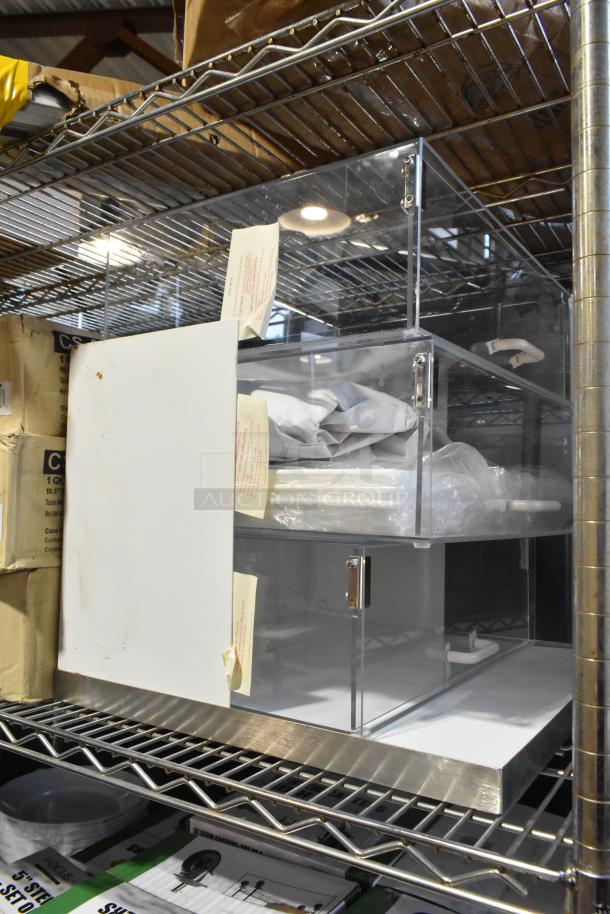 Brand new scratch and dent countertop dry display case merchandiser, clear acrylic with metallic accents, visible tags.