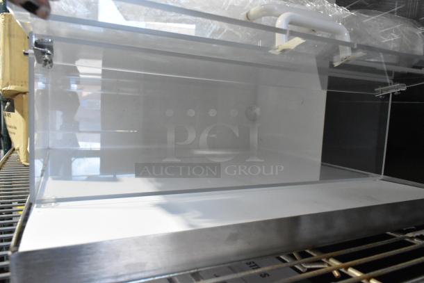 Brand new countertop dry display case merchandiser with minor scratches, transparent acrylic panels, and stainless steel trim.